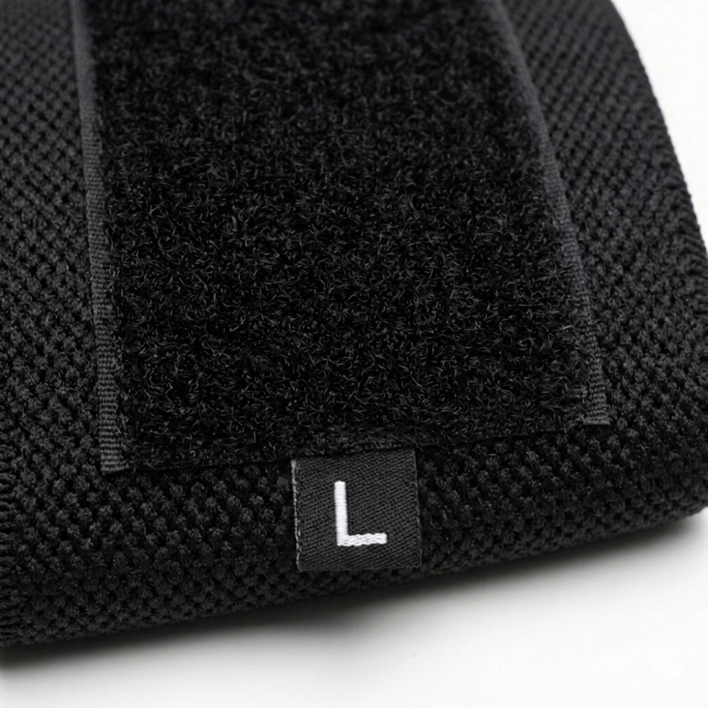 Detalhe do fecho em velcro e da etiqueta L da faixa de pulso