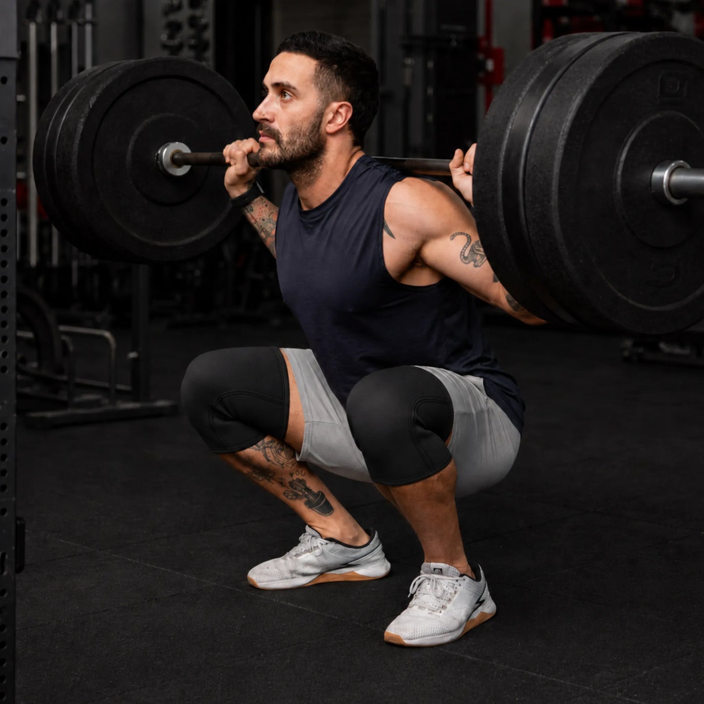 Atleta usando joelheiras de compressão durante agachamento com barra